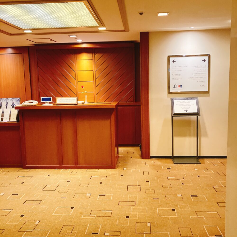 帝国ホテル東京のエグゼクティブサービスフロアの受付カウンター。ミーティングルームやビジネスラウンジが併設された、落ち着いた木目調の空間。