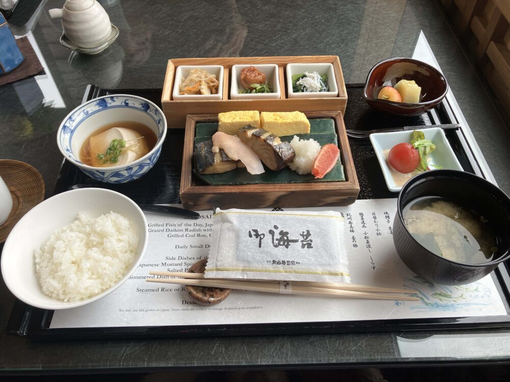 ホテル椿山荘東京の日本料理「みゆき」で提供された和朝食膳。白いご飯、味噌汁、焼き魚、出汁巻き卵、小鉢に入った様々な和え物や煮物、果物などが漆器や陶器の器に美しく盛り付けられている。