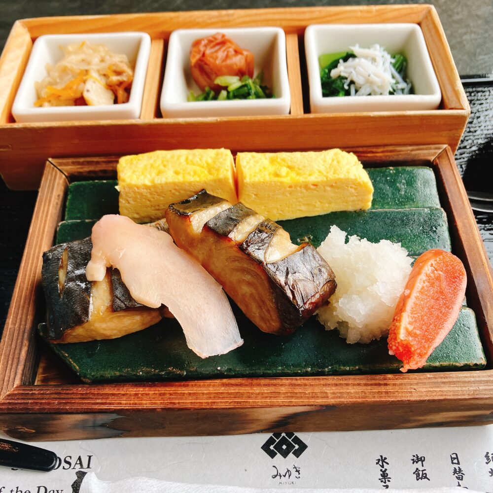 ホテル椿山荘東京の日本料理「みゆき」で提供された和朝食膳の一部。焼き魚（鯖、鱈）、出汁巻き卵、明太子、大根おろしが、伝統的な漆器に美しく盛り付けられている。
