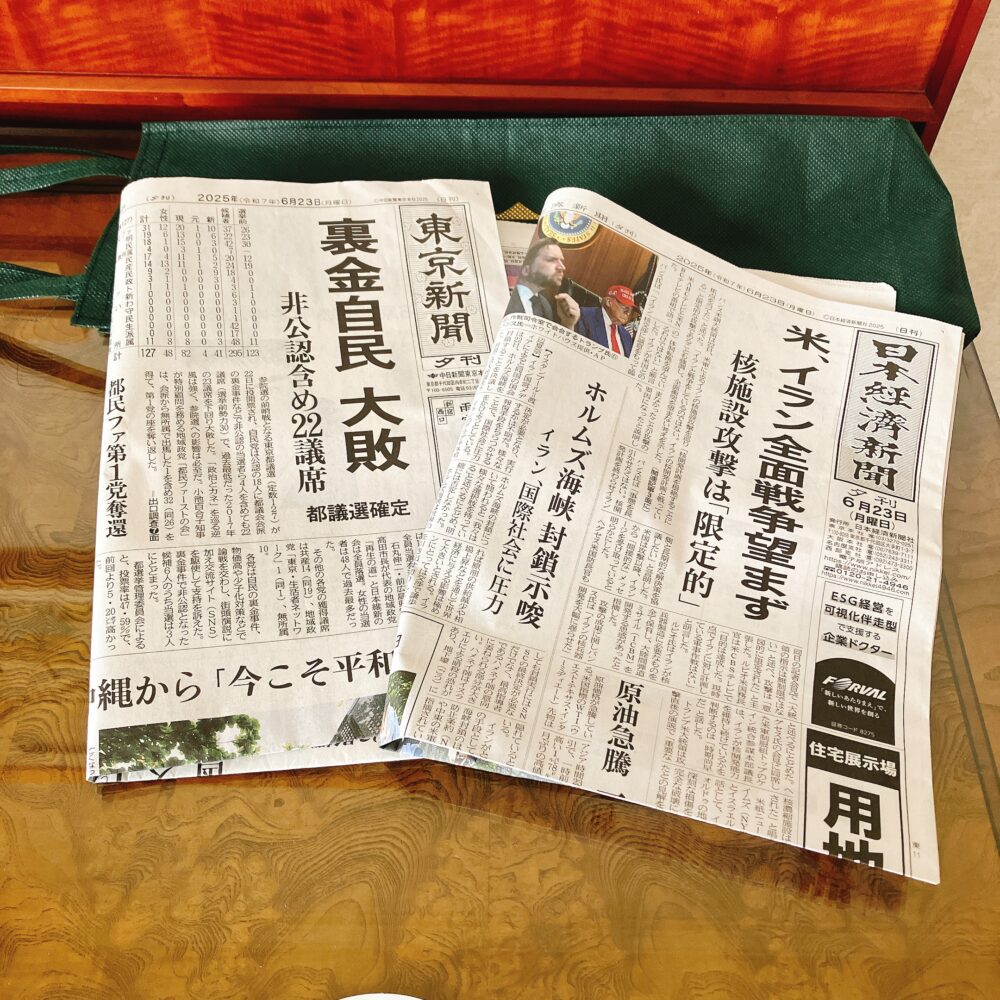 ホテル椿山荘東京の客室に届けられた朝刊。複数紙が重ねて置かれており、「東京新聞」「日本経済新聞」などのタイトルが見える。