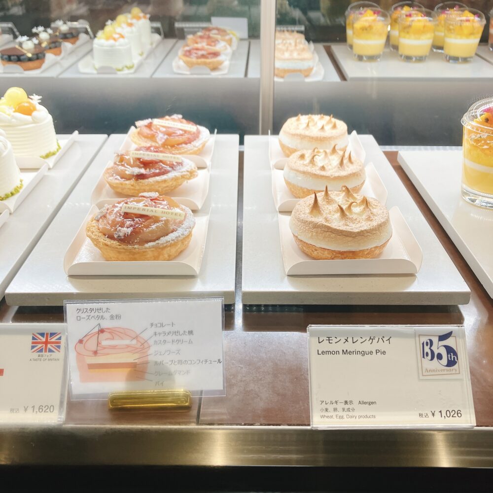 帝国ホテル東京の英国フェアで販売されているピーチパイ。バラの形にカットされた桃とローズペタルが美しく飾られ、ケーキケースに並んでいる様子。