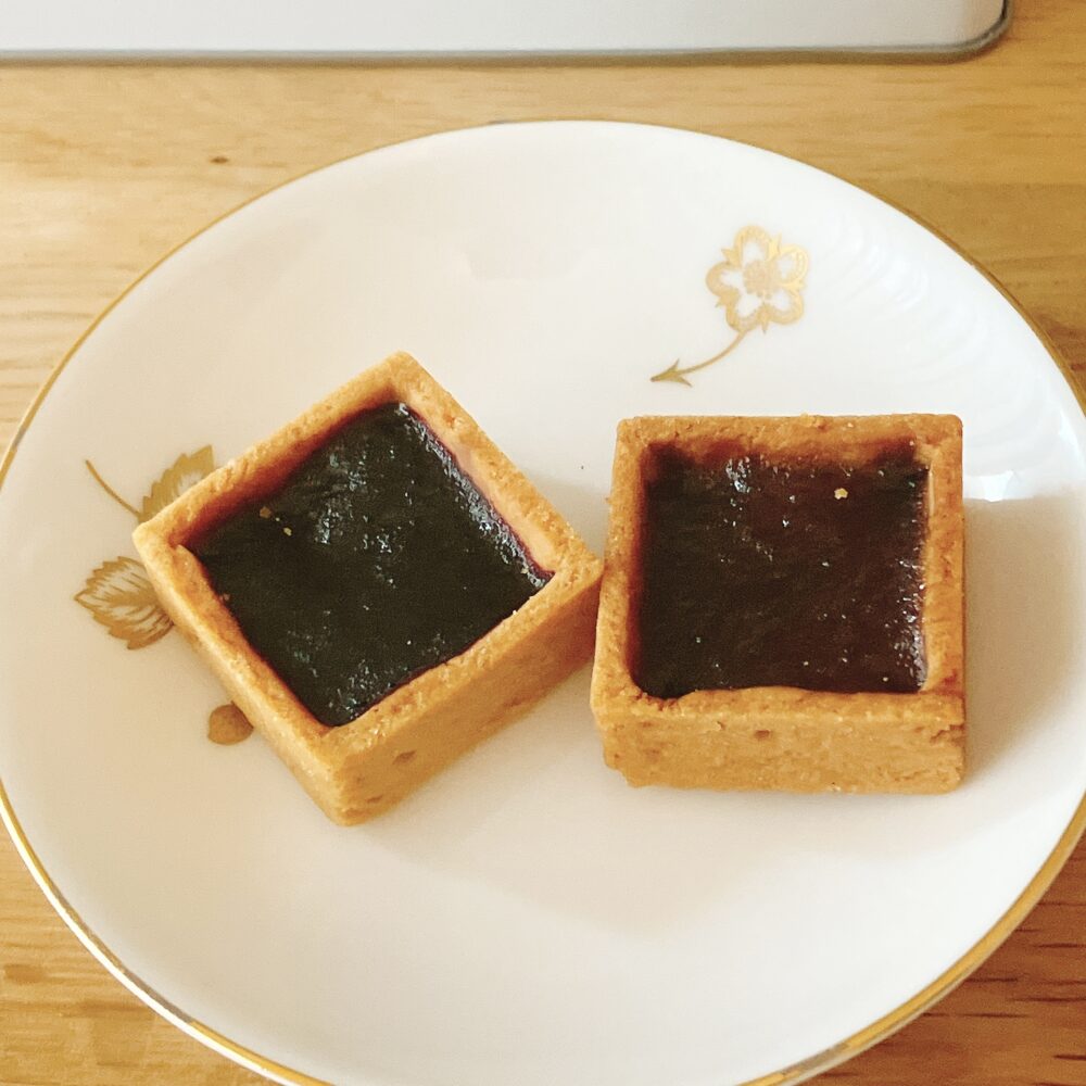 帝国ホテルのプレミアムクッキー缶に入っている、四角いタルト生地に濃厚なブルーベリーとアップルのパートドフリュイが閉じ込められたクッキー。