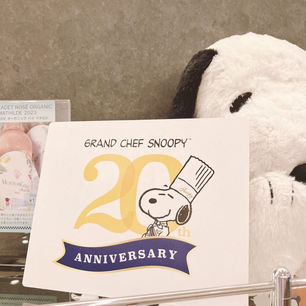 帝国ホテルのホテルショップに飾られた、料理長スヌーピー20周年を記念したディスプレイ。20th ANNIVERSARYと書かれたボードと、スヌーピーのぬいぐるみの一部が見える。