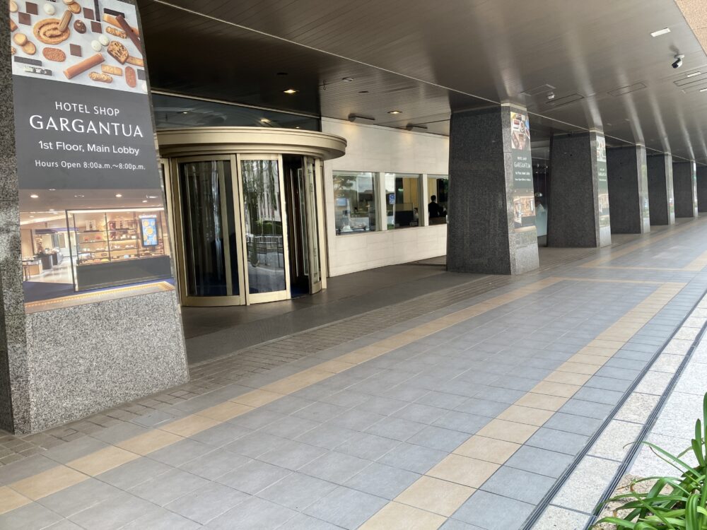 帝国ホテル東京本館1階にあるホテルレストラン横入り口。回転ドアと、ガルガンチュワの営業時間を示す看板が確認できる。
