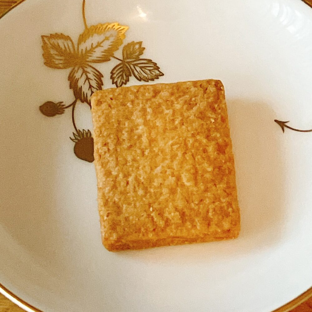 帝国ホテルのプレミアムクッキー缶に入っている、長方形のココナッツサブレ(ココ)。表面にココナッツの繊維が見えるクローズアップ写真。