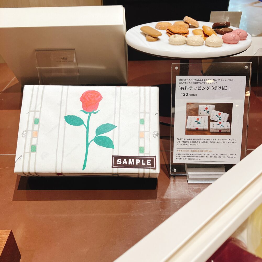 帝国ホテル ガルガンチュワの有料ラッピングに使われる、一輪の薔薇が描かれた白い掛け紙(有料のし)のサンプル。価格は132円(税込)。