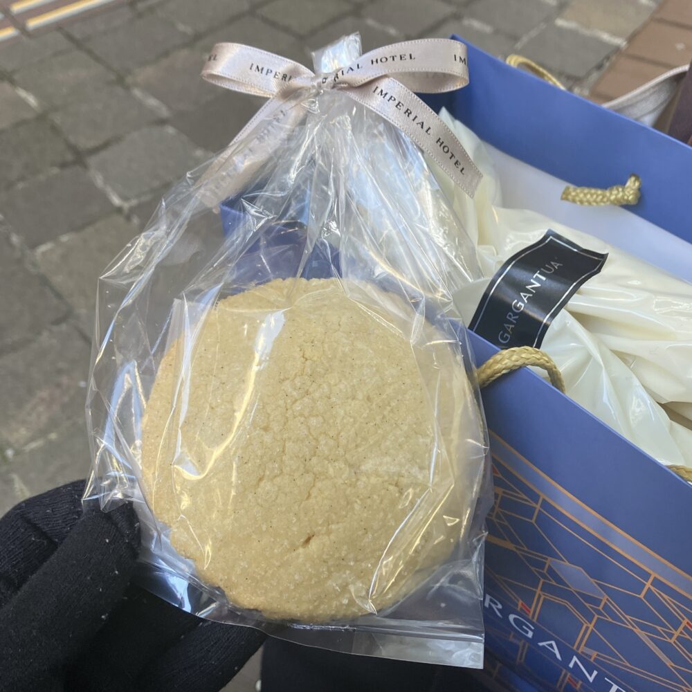 こちらが、ガルガンチュワで購入したメロンパンです。「IMPERIAL HOTEL」のリボンがかかったバッグから取り出すと、すでにハチミツの甘い香りが漂ってきます。上部のリッチなクッキー生地が、帝国ホテルらしい贅沢さを感じさせます。