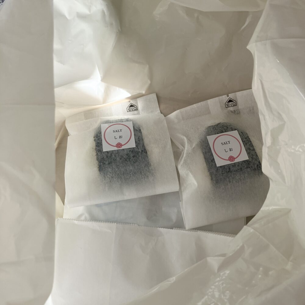 562円のおむすびにも、手厚い梱包が施されています。ビニール袋の中には、おむすびが一つずつ紙に包まれ、さらに保冷剤ががっちり入っていました。これは、おむすびを「ケーキと同じく温度変化による劣化を防ぐべき生鮮食品」として扱っている、一流ホテルの品質管理の証です。