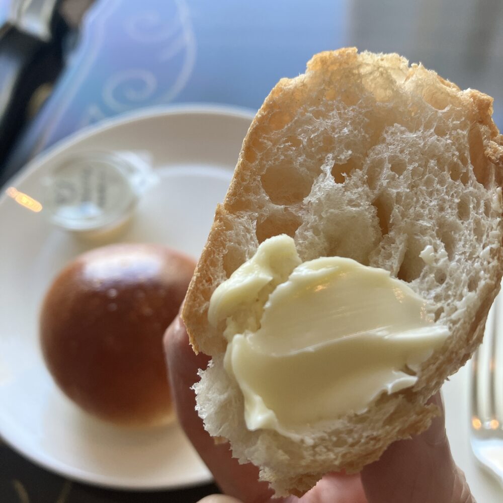 断面に帝国ホテル特選発酵バターをたっぷり塗った、バゲット・トラディションのアップ。小麦の気泡とバターの光沢が鮮明。