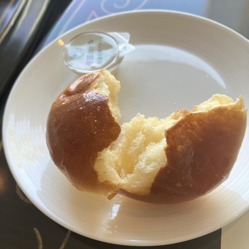 手で半分に割った帝国ホテルの伝統的なバターロール。中の生地のふんわりとした質感が強調されている。