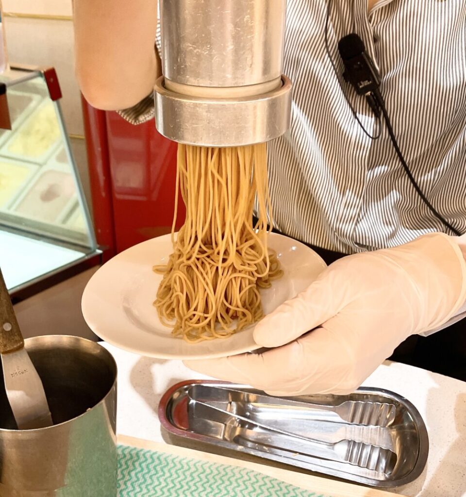 スタッフが専用の機械を使って、お皿にモンブランクリームを搾り出している様子。