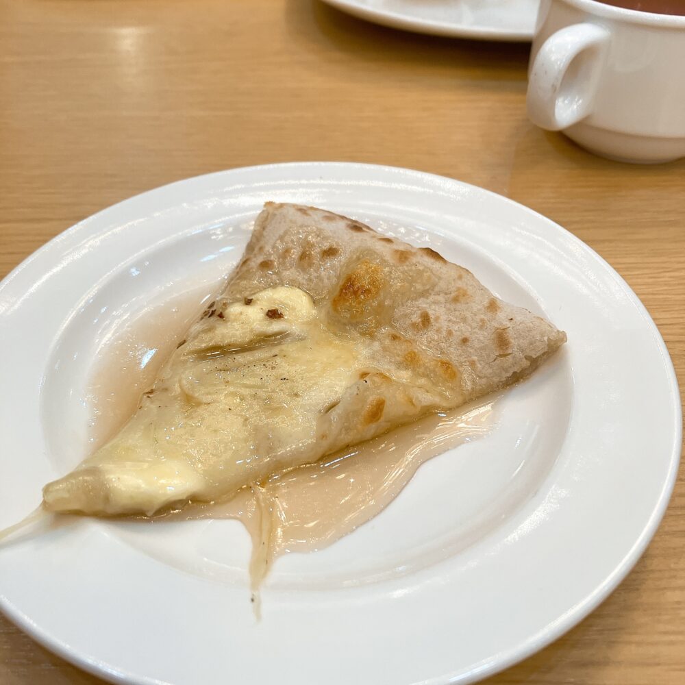 クアトロフォルマッジ（チーズピザ）にハニーメイプルをたっぷりかけたお皿。