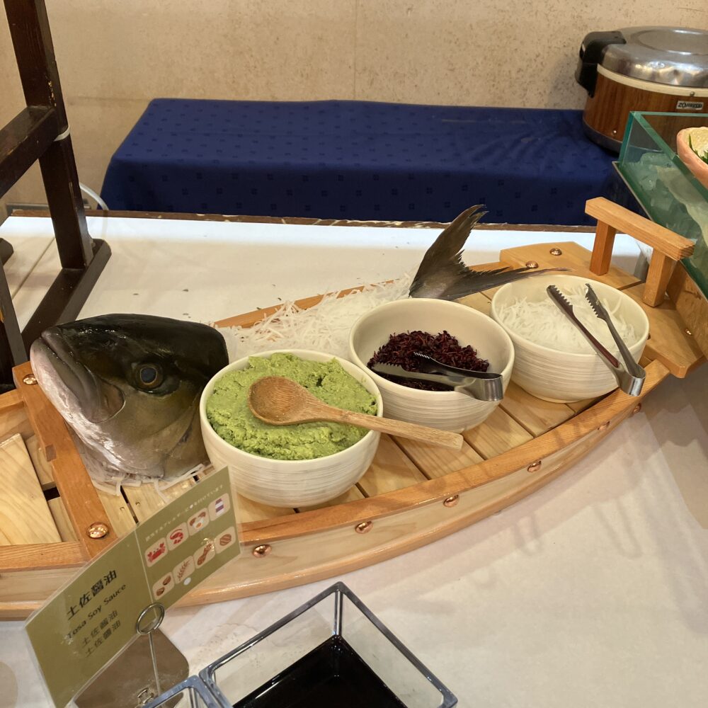 舟盛りに乗った巨大なマグロのカブトと、土佐醤油などの薬味。