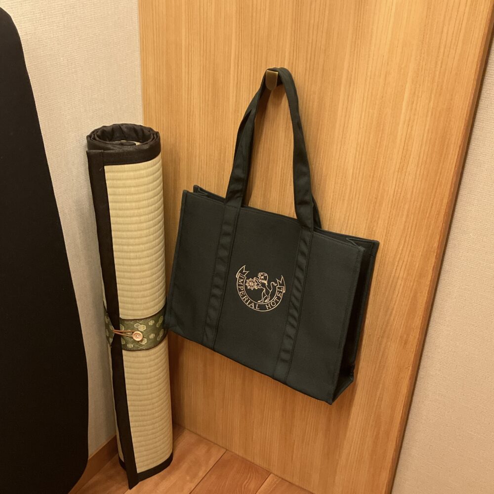帝国ホテル京都の客室クローゼット。お持ち帰り可能なオリジナルロゴ入りトートバッグ(ショップで4,500円相当)と、荷物置きやヨガマットとして使える和室ならではの畳マット