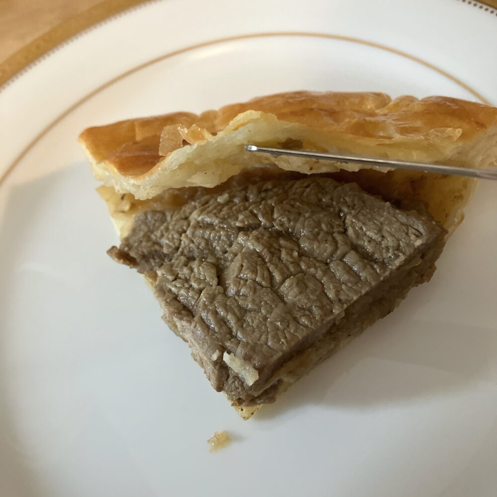 帝国ホテル「シャリアピンパイ」の断面。甘めのタレが染みた炒め玉ねぎとお肉のジューシーな層