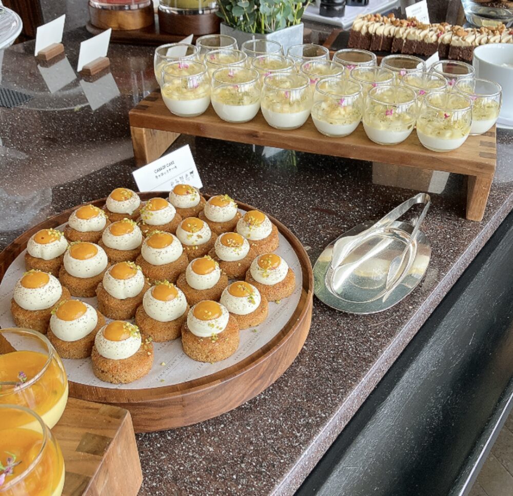 丸く絞られたクリームが特徴的なキャロットケーキ。奥にはピーチパンナコッタなどの涼しげなグラスデザートが並んでいる。