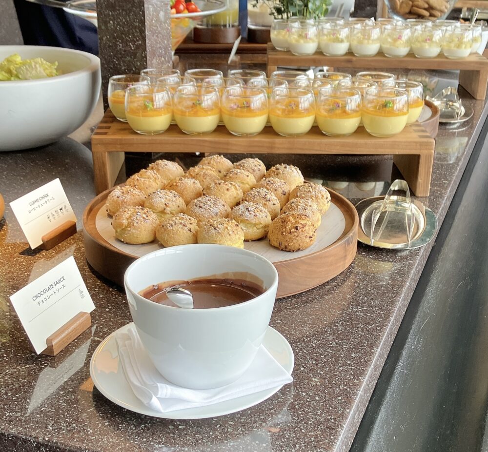 ニューヨークグリルのスイーツブッフェに並ぶ一口サイズのコーヒーシュークリームとチョコレートソース。