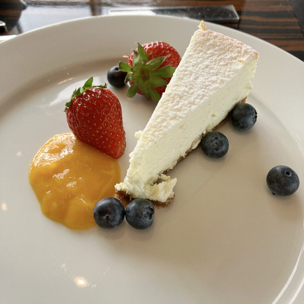 パークハイアット東京 ニューヨークグリル名物のニューヨークチーズケーキ。濃厚でクリーミーなチーズケーキに鮮やかなマンゴーソースと苺・ブルーベリーを添えた、ここでしか食べられない一品。