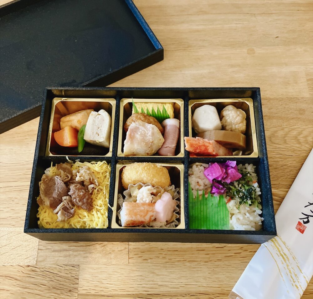 ガルガンチュワで購入した「なだ万」の和食弁当(※15%割引対象外)。6つの仕切りに肉や魚、彩り豊かなおかずが詰まっている。