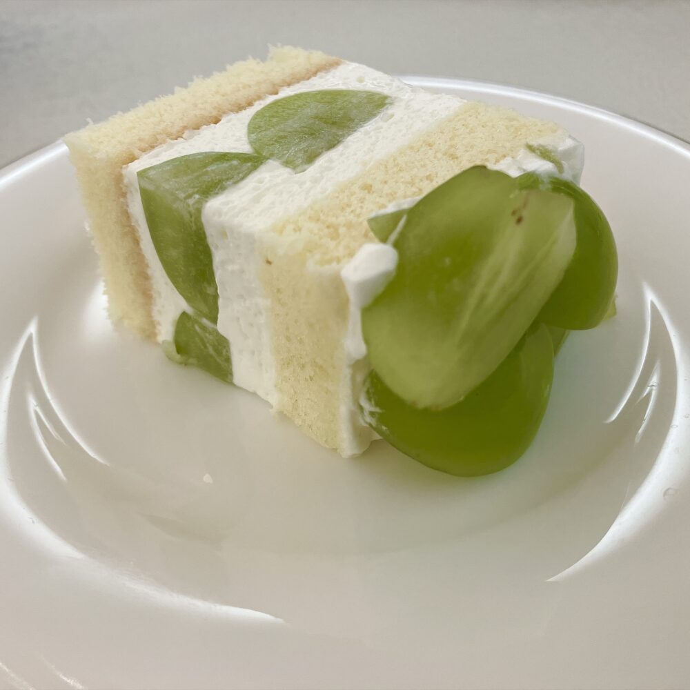 切り分けられた「大きなショートケーキ シャインマスカット」。しっかりとしたスポンジの間に、高級なシャインマスカットが贅沢にサンドされた断面