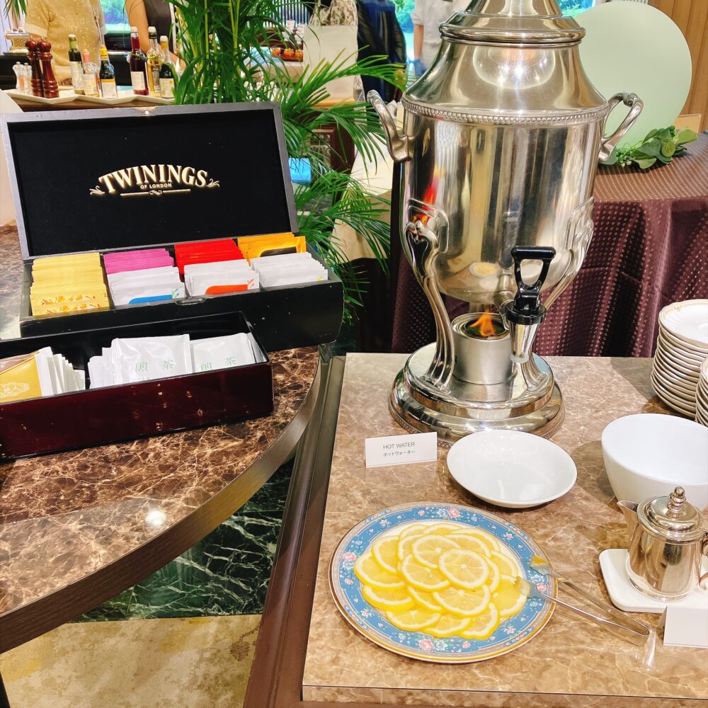 ドリンクコーナーに用意されたTWININGS（トワイニング）のティーバッグ入り木箱と、優雅なティータイムを演出する本格的なシルバーのサモワール（湯沸かし器）