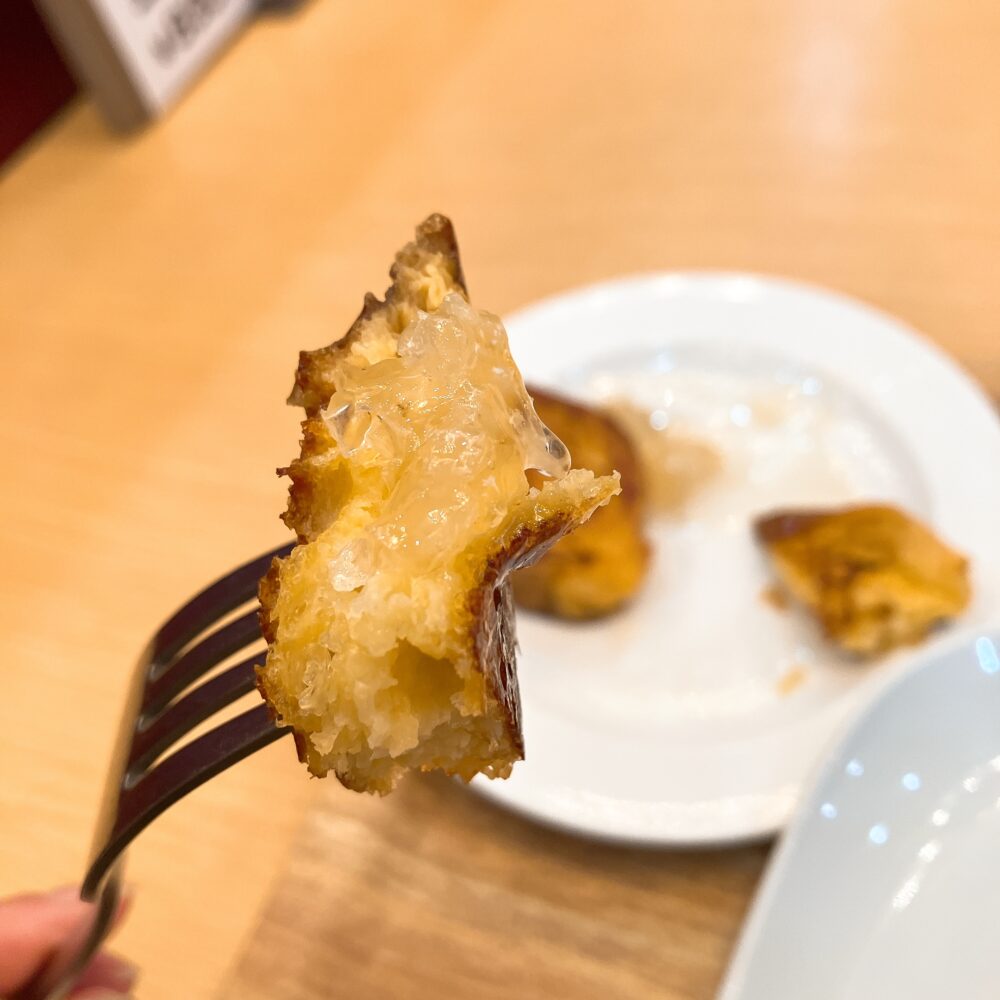 フォークに刺したフレンチトーストに、とろけるコムハニー（巣蜜）がたっぷり絡んでいるシズル感のあるアップ写真。