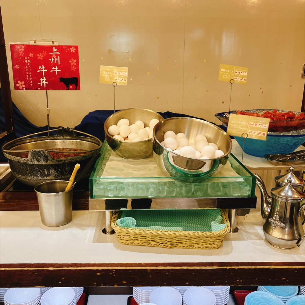 ホテル櫻井の朝食バイキングにある上州牛牛丼のコーナー。大きな鍋で煮込まれた牛丼の具と、たっぷりの温泉卵が並んでいる。