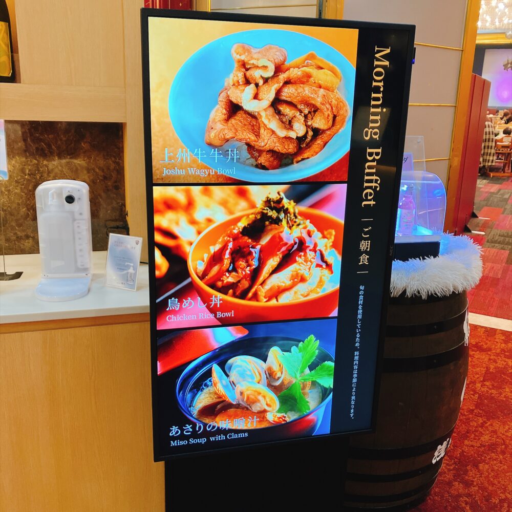 ホテル櫻井の朝食バイキングで提供される「上州牛牛丼」「鳥めし丼」「あさりの味噌汁」が映し出されたデジタルサイネージ。
